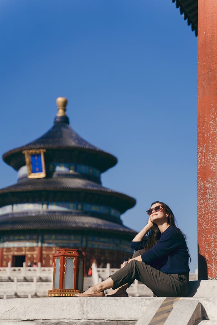 Chica en beijing con un templo atrás